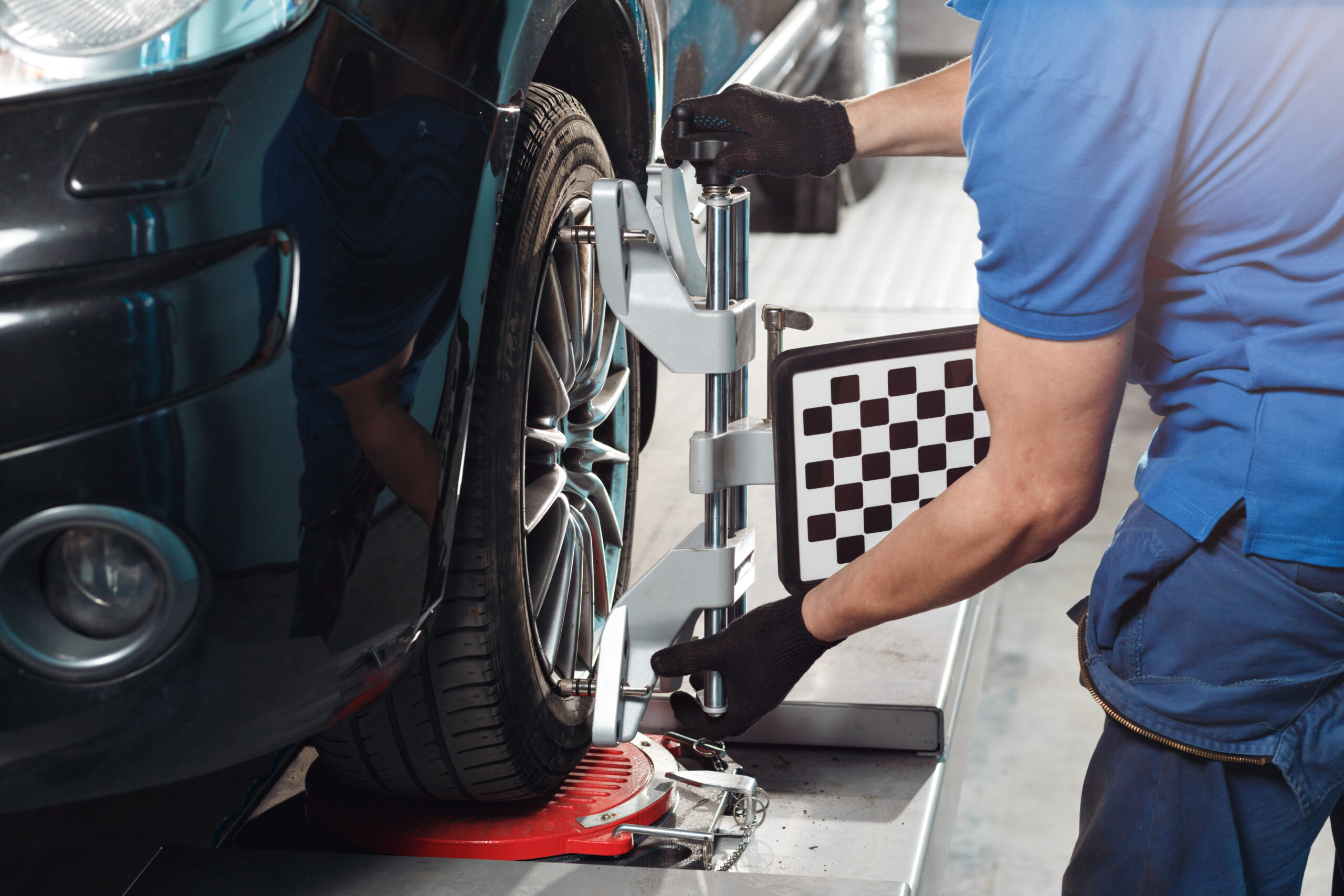 Grid sensor sets mechanic on auto. Car on stand with sensors wheels for alignment camber check in workshop of Service station